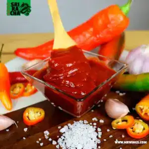 salsa sriracha en tazón blanco con sus ingredientes alrededor